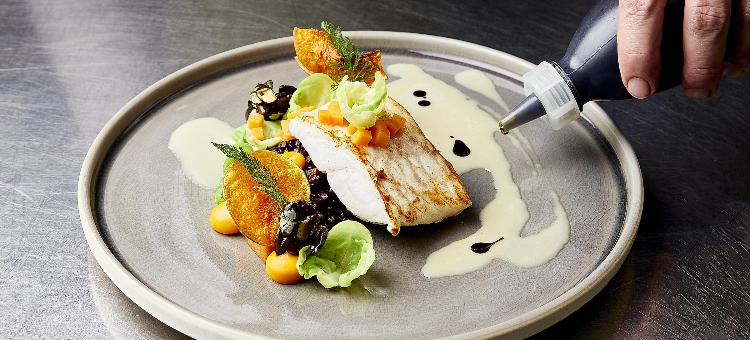 Plating a fish dish with sauce