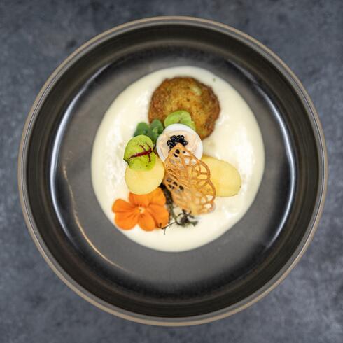 Exquisites Gericht mit Kartoffelpuffer, Kaviar und Blüte