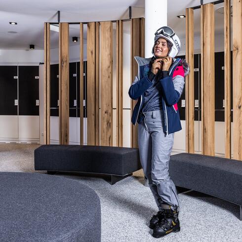 Smiling woman in ski clothing in the ski room