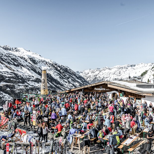 Fröhliche Après-Ski-Party auf sonniger Berghütte | © Alexander Maria Lohmann