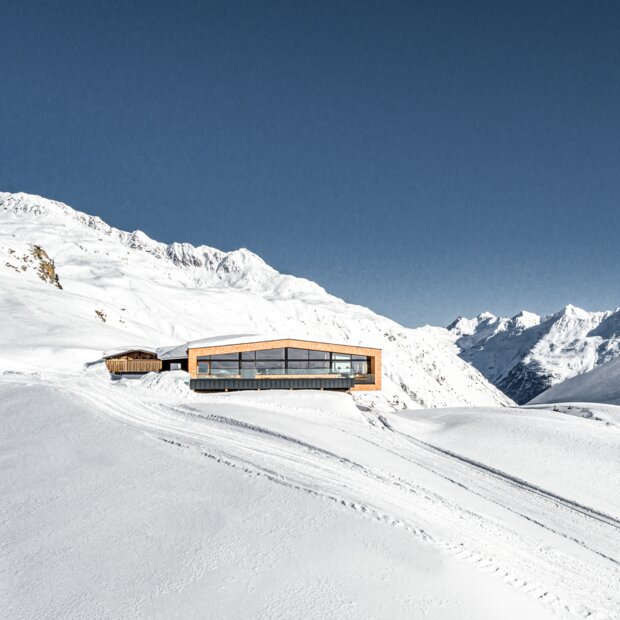 Modernes Holzgebäude in schneebedeckter Berglandschaft | © Alexander Maria Lohmann