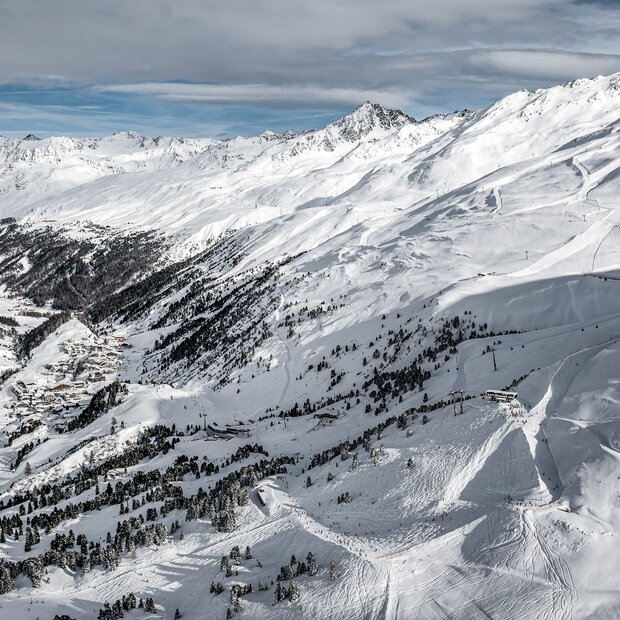 Verschneite Alpenlandschaft mit Skigebiet und Dorf | © Alexander Maria Lohmann