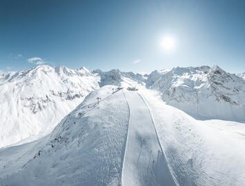 Winter mountain panorama with ski slope and sunshine