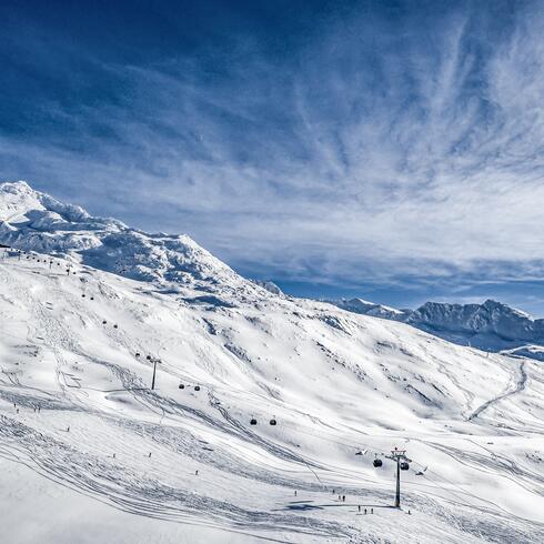 Verschneite Berge mit Skipisten und Gondelbahn | © Alexander Maria Lohmann