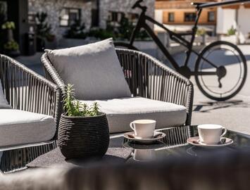 Sunny garden seating area with coffee cups and plant